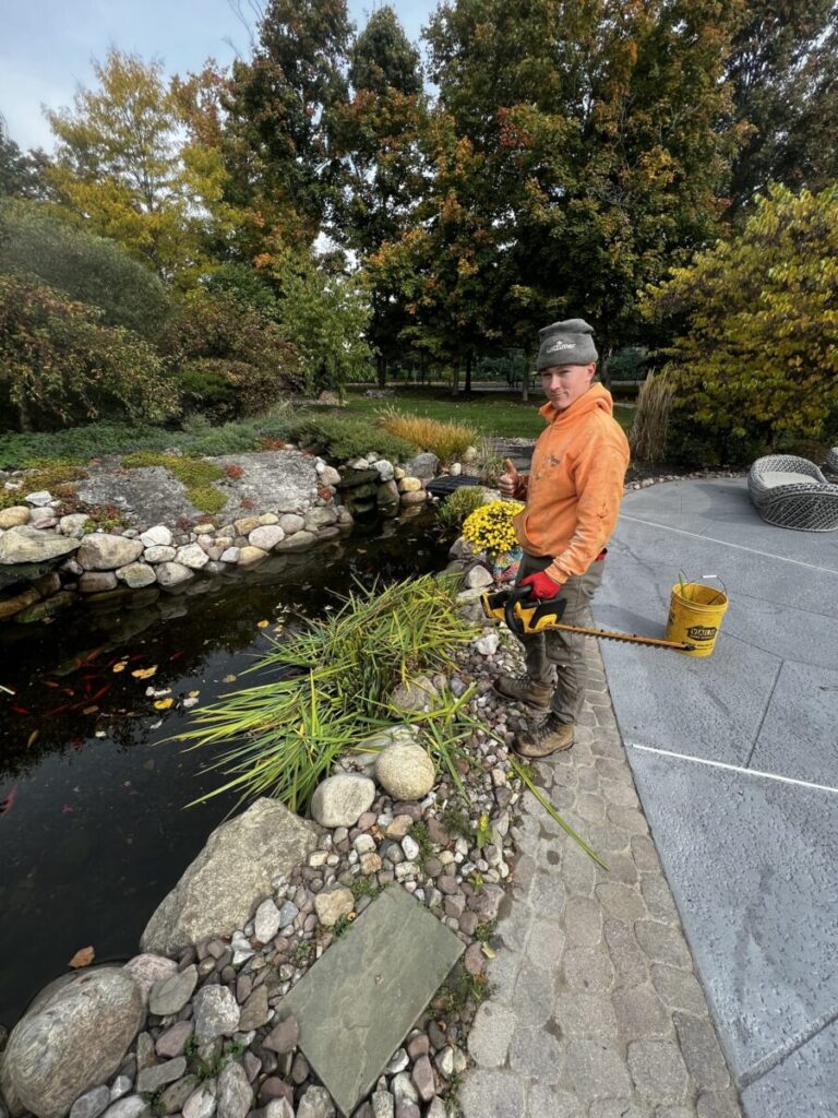 Using hedge trimmer by the pond